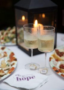 Wine glasses on a candle lit table at the 100 Women with $100 fundraising event for Maureen's Hope Foundation.